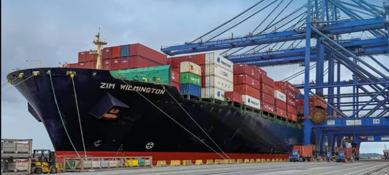 Porta-contêineres ZIM Wilmington atracado no Terminal de Contêineres de Paranaguá, sob os portêineres azuis do terminal